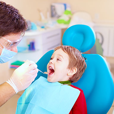 Child receiving dental checkup from a dentist in a clinic.