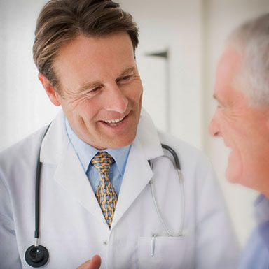 Doctor smiling and talking to an elderly patient.